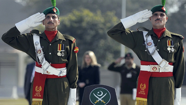 Pakistan Army personnel saluting in British-style, palms facing outward.